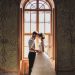 Dobrý svadobný fotograf - nevesta so ženíchom pred starobylým oknom